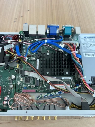 The motherboard lifted a few centimeters, its cables still connected